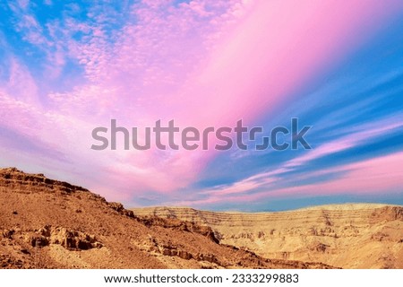 Mountainous desert with colorful cloudy sky. Judean desert in Israel at sunset