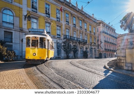 Famous vintage yellow tram 28 in the narrow streets of Alfama district in Lisbon, Portugal - symbol of Lisbon, famous popular travel destination and tourist attraction Royalty-Free Stock Photo #2333304677