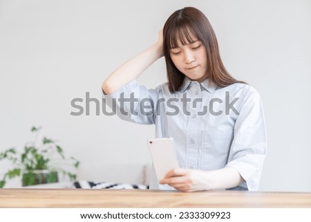 Young attractive Asian woman using a smartphone,think, Royalty-Free Stock Photo #2333309923
