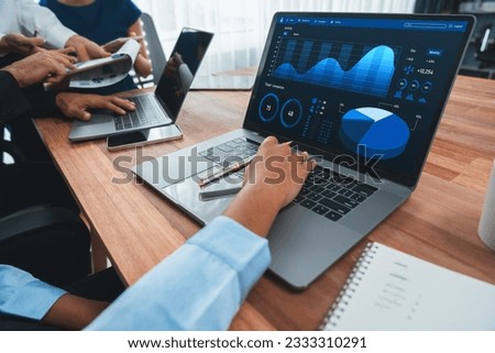Multiracial analyst team use BI Fintech software to analyze financial data on meeting table. Financial dashboard data display on laptop screen with analyzed chart for marketing indication. Concord Royalty-Free Stock Photo #2333310291