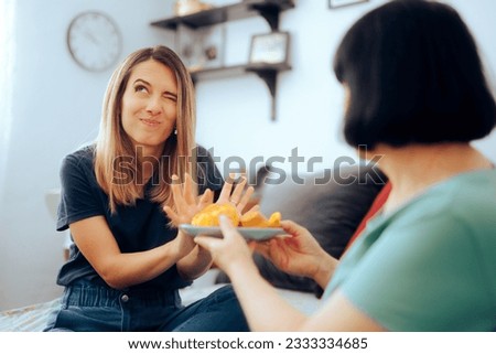
Daughter Refusing her Mom Trying to Overfeed her 
Mother overfeeding her adult daughter when she visits
 Royalty-Free Stock Photo #2333334685