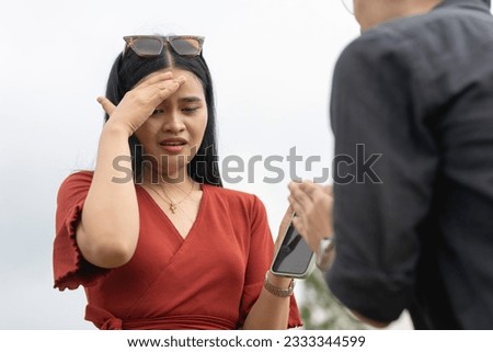 A young man confesses his infidelity and seeing another woman to his girlfriend, who breaks down and gets emotional. A regretful boyfriend saying sorry to an inconsolable woman. Royalty-Free Stock Photo #2333344599