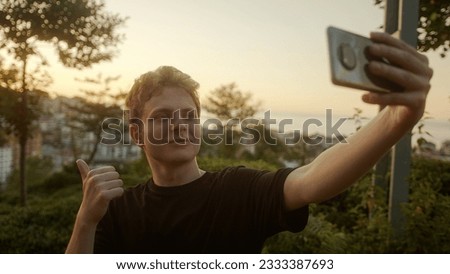 Capturing Moments: Handsome Blond Young Man Taking Selfies with His Smartphone, Striking Various Poses Outdoors