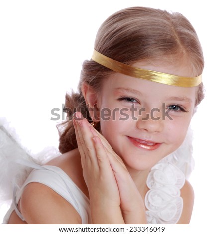 Studio image of lovely angelic little girl praying to the God on Christmas holiday isolated on white background/Pretty caucasian little angel looking up and praying gratefully 