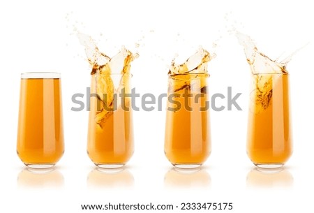 Set of four apple yellow cool juices in glass with reflection, calm and  juicy splashes and drops fly isolated on white background. Ripe summer fruit gold drink with bubbles, swirl and splashing.