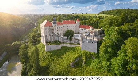 Traveling Poland castle concept: Panoramic Aerial view of Pieskowa Skała Renaissance castle, standing on Little Dog's Rock  limestone cliff in the green forest valley of river Prądnik. Summer, sunset. Royalty-Free Stock Photo #2333475953