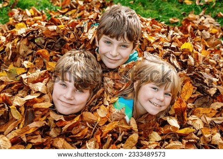 Portrait of three siblings children. Two kids brothers boys and little cute preschool sister girl having fun together in autumn park. Happy healthy family playing, walking, active leisure on nature Royalty-Free Stock Photo #2333489573