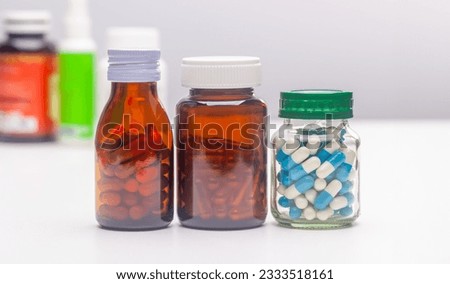 Unlabeled pill bottles lined up on a white background