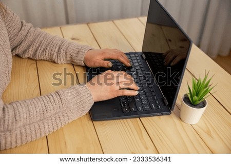 Close up picture of womans hands typing. Woman using the laptop at home, no face. Woman typing on laptop keyboard. Business woman working at laptop, no face. Hands of a female freelancer