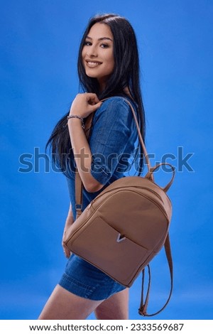 a young brunette with long hair posing in the studio with a backpack, Back to school concept.