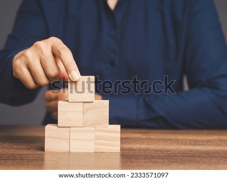 Businessman stacking blank wooden cubes on the table. Six empty wooden cubes for input wording and infographic icon. Space for text.