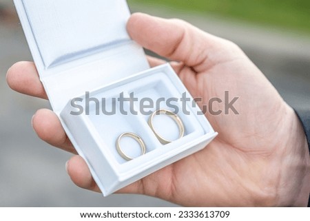 Groom hold in hand Romantic marriage couple wedding Symbols rings in a white box