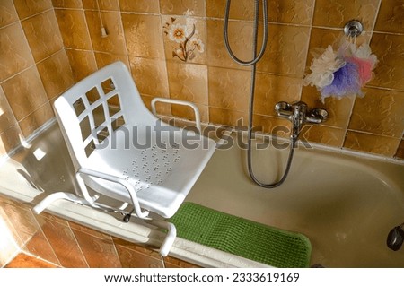 Swivel chair positioned on the bathtub for use by disabled individuals and elderly people with difficulty in walking to enter the bathtub Royalty-Free Stock Photo #2333619169