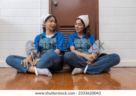 Two young professional housewives cleaning the house Royalty-Free Stock Photo #2333620043