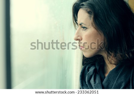 beautiful 35 year old woman stands in front of the window Royalty-Free Stock Photo #233362051