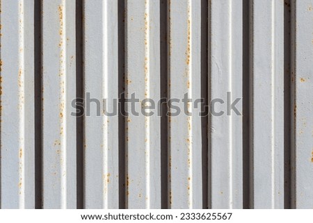Close up of a corrugated painted metal sheet with rusty spots. Industrial background.