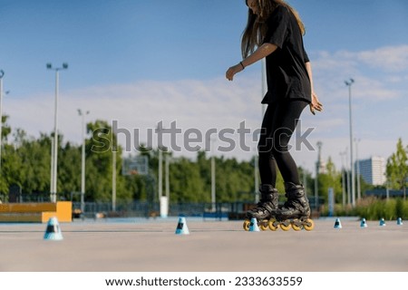 sporty girl practicing tricks on roller skates in park on city background enjoying roller skating lesson with chips closeup Street sports concept
