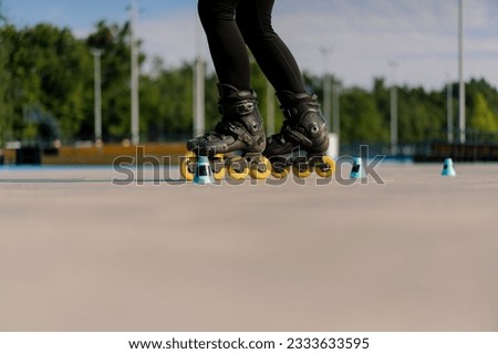 sporty girl practicing tricks on roller skates in park on city background enjoying roller skating lesson with chips closeup Street sports concept