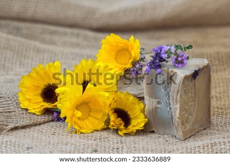 Natural handmade soap with calendula, lavender and herbs on rustic wooden background