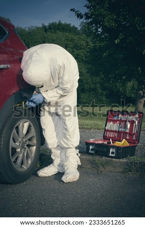 Crime scene investigation - collecting of evidences of soil samples on car wheel Royalty-Free Stock Photo #2333651265