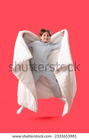 Jumping little boy with blanket on red background Royalty-Free Stock Photo #2333653981