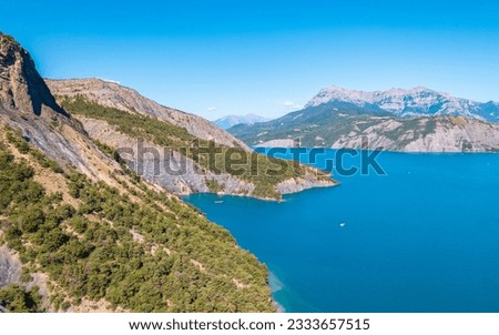 Aerial photography by drone of the Serre-Ponçon lake and its mountains, located in the Hautes-Alpes in France