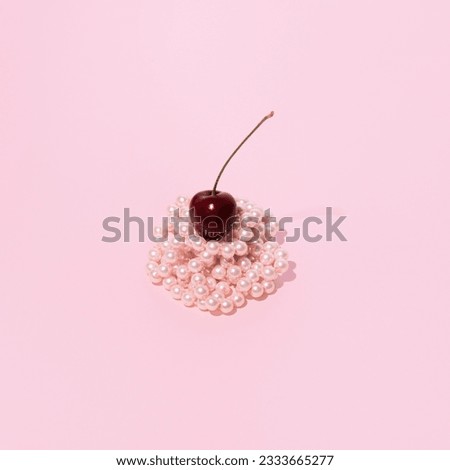 Pastel pink pile of  pearl beads, a fresh juicy cherry on top, creative aesthetic fruity dessert idea. 