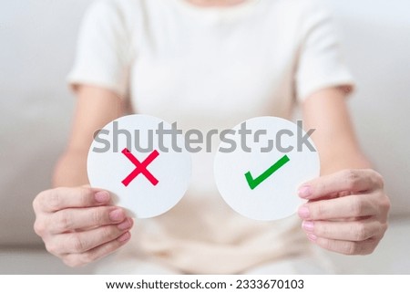 Woman show Wrong and Right symbol paper. True and false, accept and rejected, evaluation, Vote, Poll, Yes or No and Survey concepts Royalty-Free Stock Photo #2333670103
