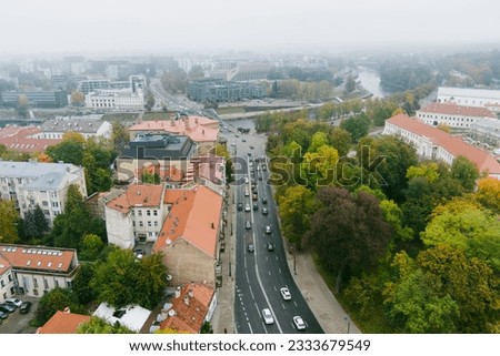 Beautiful foggy Vilnius city scene in autumn with orange and yellow foliage. Aerial early morning view. Fall city scenery in Vilnius, Lithuania.