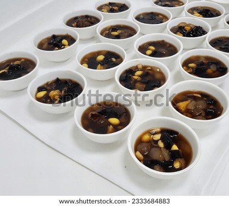 a photography of a table with bowls of soup and a plate of corn, bowls of soup with corn and beans in them.