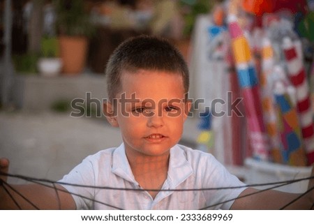 Boy holding a fishing net at the seaside during sunset stock photo