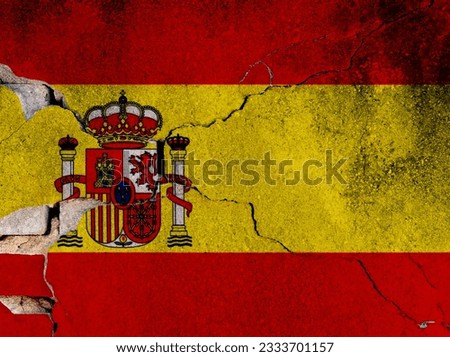 Spanish flag on cracked concrete wall.