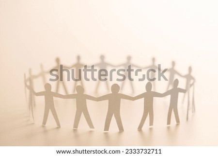 Cutout paper people standing in circle holding hands. Royalty-Free Stock Photo #2333732711