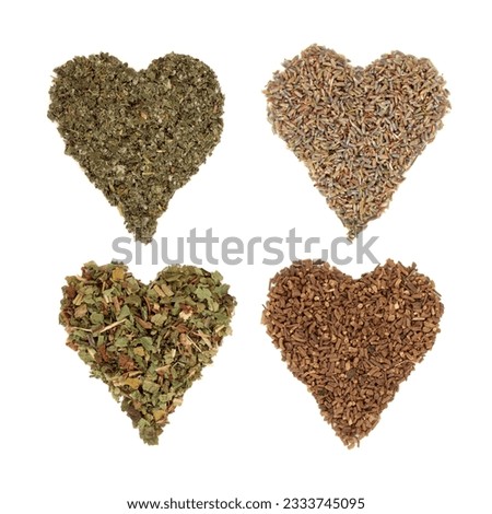 Medicinal dried herbs of comfrey, lavender, raspberry and valerian in heart shaped piles, from top left to bottom right, over white background.
