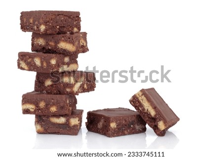 Chocolate brownie cake stack with loose chunks to one side, over white background.