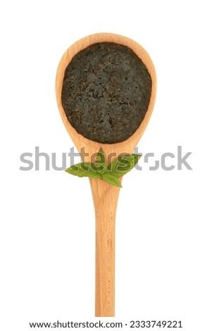 Mint sauce jelly in a wooden spoon with leaf sprig isolated over white background.