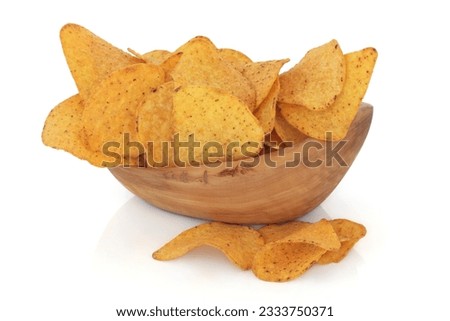Tortilla chips in an olive wood bowl and scattered, over white background.