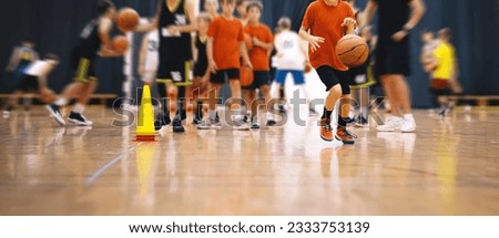 Children on basketball training. Group of school boys practicing basketball with a young coach. Kids play sports during a basketball training drills on a wooden court Royalty-Free Stock Photo #2333753139