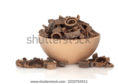Magnolia bark used in chinese herbal medicine in a beech wood bowl isolated over white background. Hou pu. Cortex magnoliae officinalis