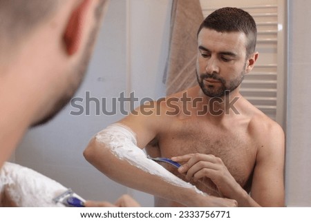 Man shaving his hairy forearms 