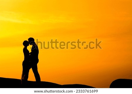 Silhouette of couple kissing in sunset