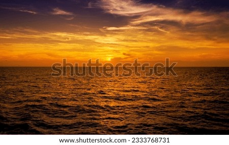 warm sunset on open ocean. The focus is on the sun.