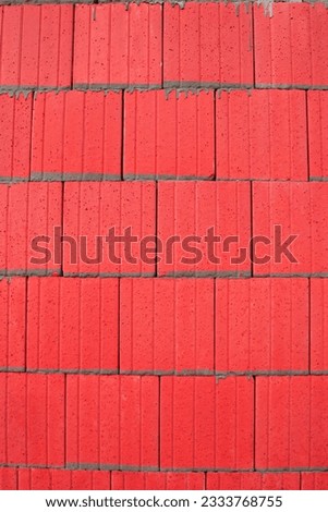 Abstract in red of tiles with grey cement pointing.