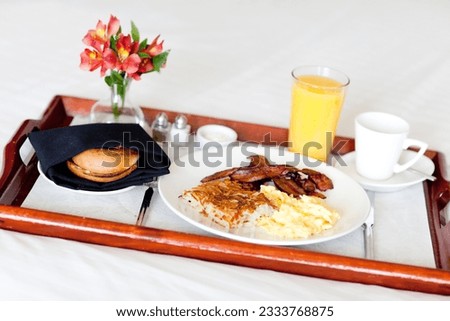 delicious breakfast served on the tray on the hotel room bed