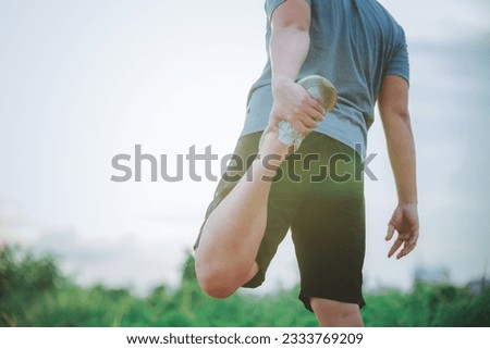 Man runner warm up outdoor. Handsome man in sportswear stretching his arms and legs for warming up his body before running. Image of exercise for good healthy.