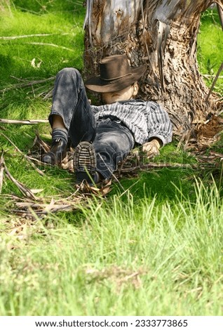 A child sleeps under a gum tree in a secluded spot on the northern slopes of the range