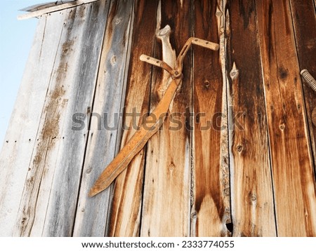 Rusted tools on side of barn.