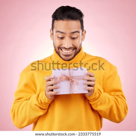 Man, winner and excited for gift box, prize and giveaway celebration or birthday surprise on pink background. Happy person with present, package and retail shopping or competition success in studio