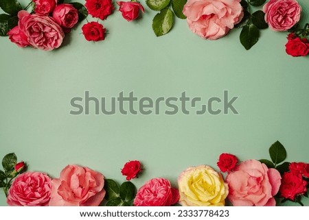 Women's Day concept. Top view photo of pink rose buds and sprinkles on isolated pastel green background with copy space