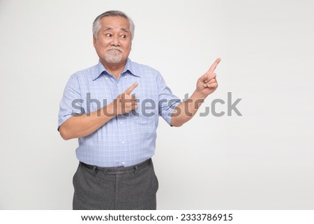 Happy Asian old man pointing to copy space blank space isolated on white background Royalty-Free Stock Photo #2333786915
